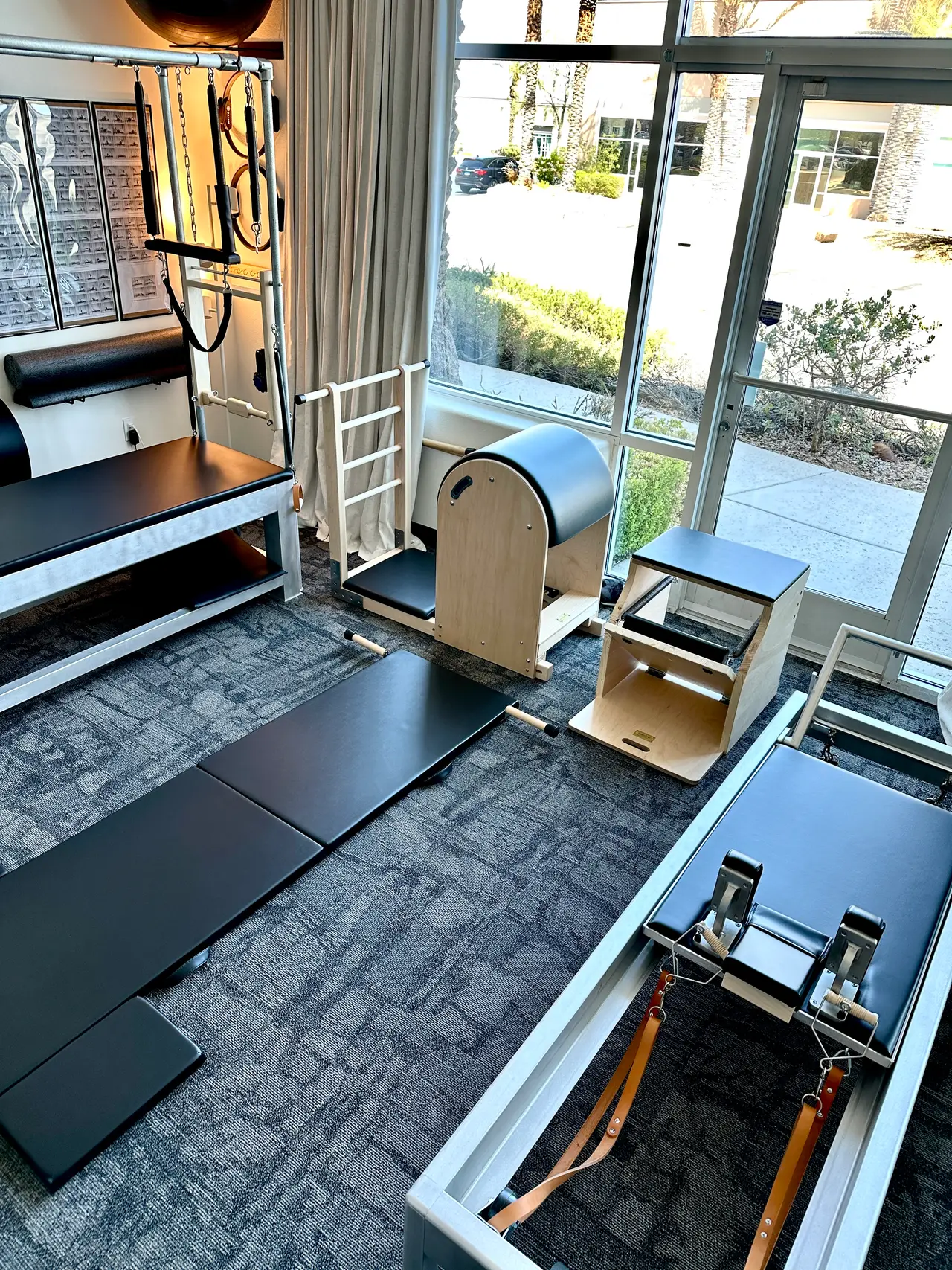 Classical Pilates apparatus room with a Cadillac tower, Ladder Barrel, Wunda Chair, and Reformer