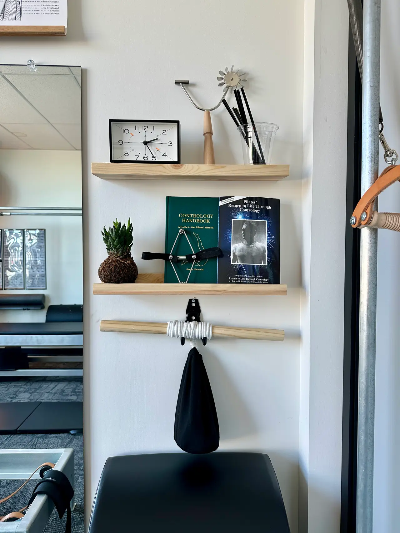 Joseph Pilates' Contrology handbooks and a classical Pilates foot corrector displayed in the Stance Pilates studio