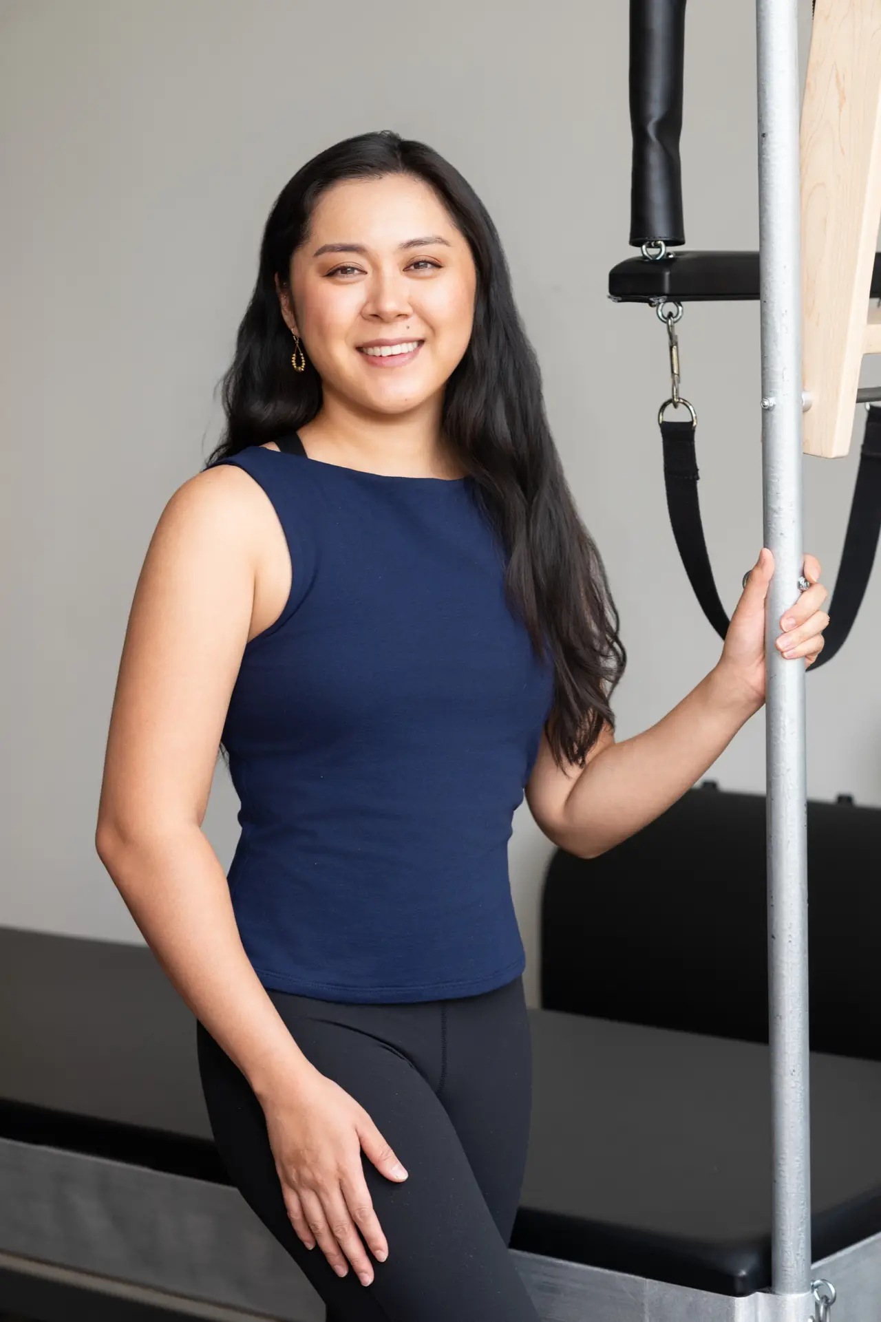 Teya Lorts, founder of Stance Pilates, standing beside the Cadillac in her Las Vegas studio